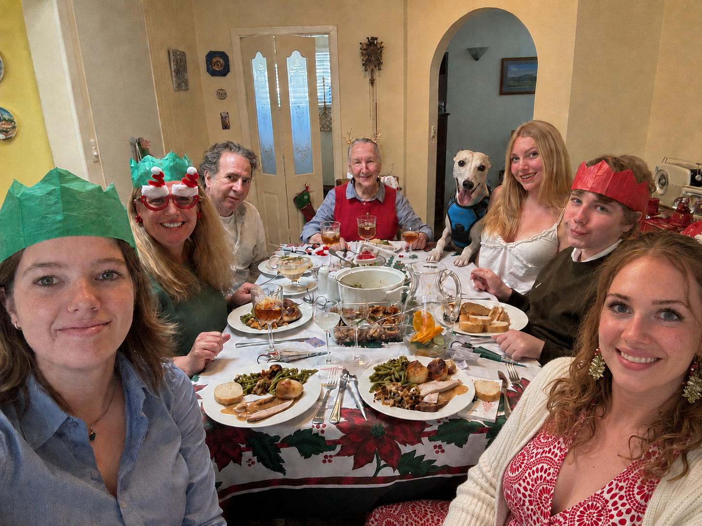 A family wearing paper crowns enjoying a Christmas dinner party together.