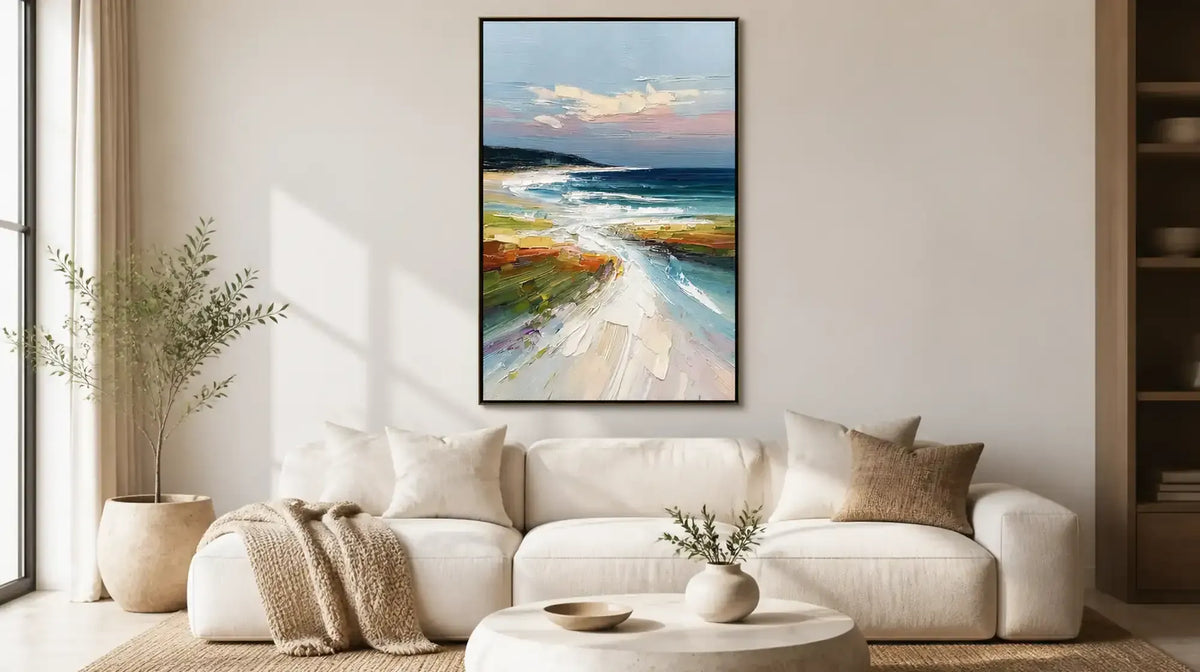Vertical coastal landscape painting above sofa adding depth to a living room