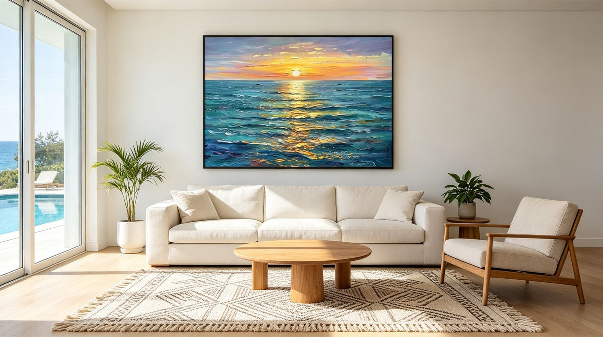 Coastal living room with a framed ocean sunset painting above a white sofa