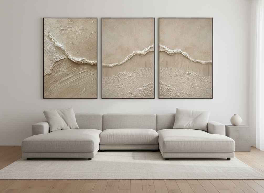 Three-piece abstract wall art set in warm neutral tones with visible texture, arranged above a sofa in a modern living room