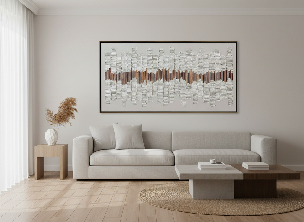 Large framed abstract wall art hung in a bright living room above a sofa