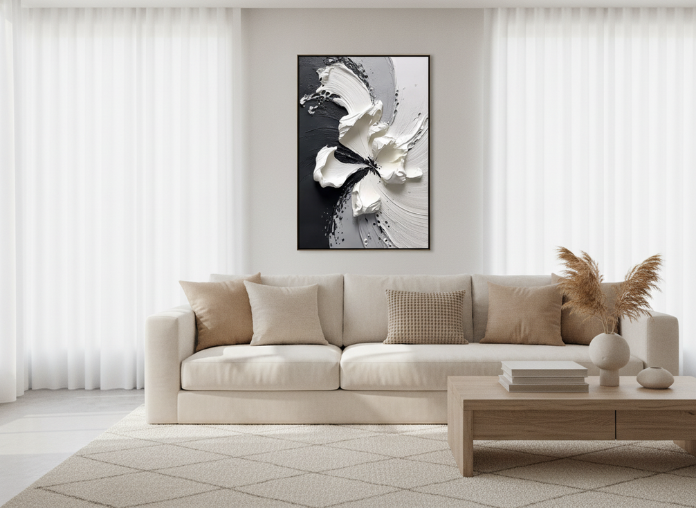 Black and white textured abstract wall art in a modern living room with warm neutral furnishings and soft natural light