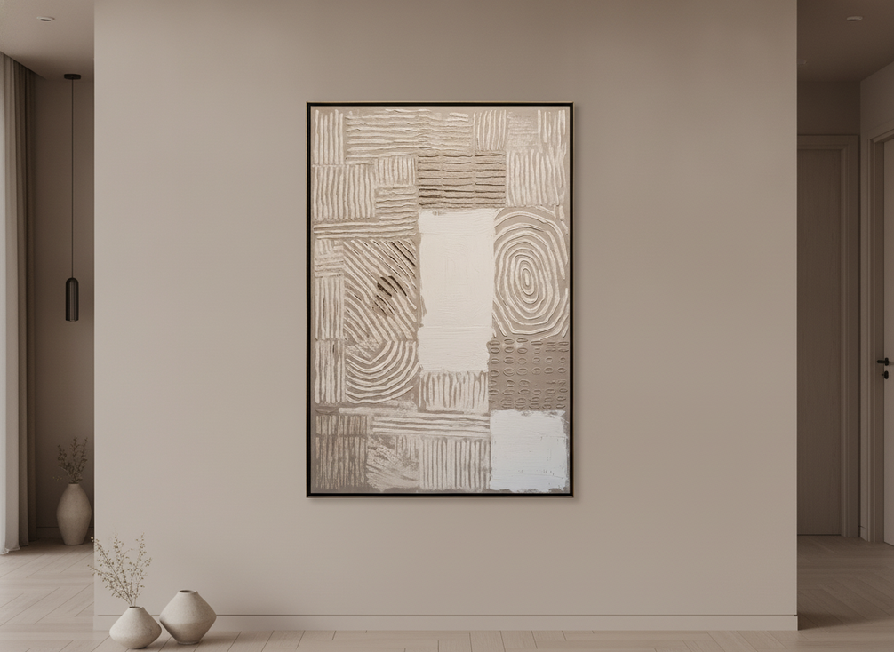 Textured abstract wall art in neutral tones displayed on a light wall in a dim room, shown as a room-facing editorial hero image