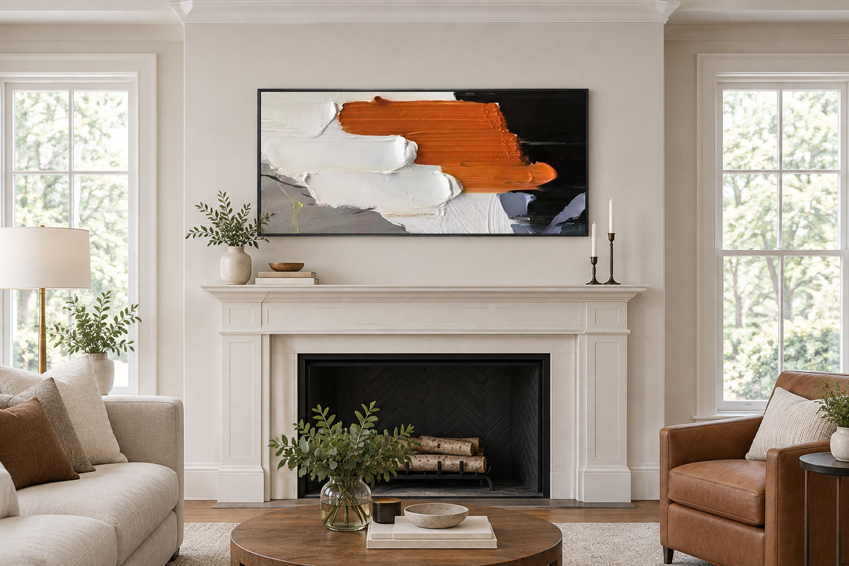 Framed canvas artwork centered above a fireplace mantel in a living room, showing balanced wall placement.