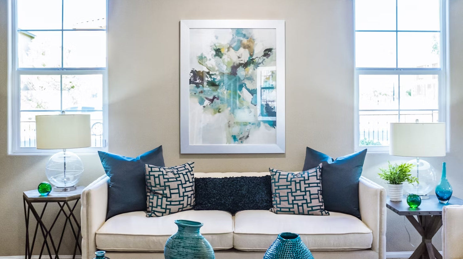 Modern living room featuring abstract acrylic painting above white sofa creating stunning accent wall with blue color palette