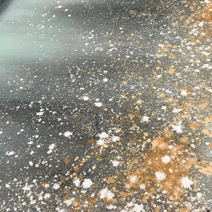 AURORA DUST: Close-up texture of abstract painting with gold, white, brown speckles on grey and teal.