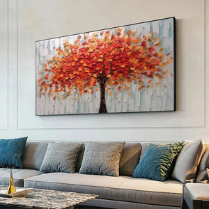 Isabella Rossi's 'Autumn Fire' textured impasto tree painting with vibrant orange-red leaves, hung above a modern grey sofa.