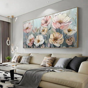 Textured impasto floral painting of soft pink and white blossoms above a beige sofa, lifestyle setting.