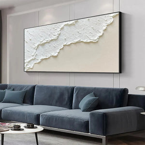 Textured white wave abstract painting, black frame, over a blue sofa in a modern living room setting.