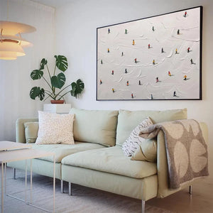 Javier Ramirez "Ski Slopes" minimalist textured white painting with colorful skiers, displayed in a modern living room.
