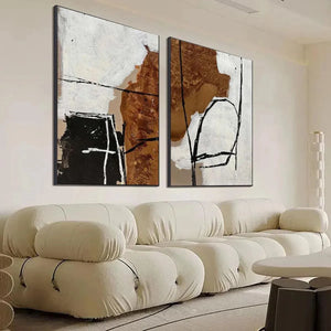 Javier Ramirez diptych: abstract brown, white, cream vertical paintings with textured brushstrokes & black lines in living room.