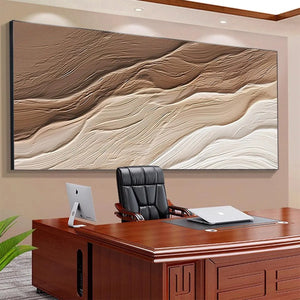 Textured abstract landscape painting 'Desert Flow' in brown and beige, displayed in a home office setting above a desk.