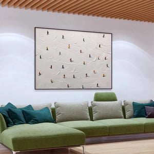 Javier Ramirez minimalist painting "Ski Slopes" with colorful skiers on textured white snowy slope, in living room.