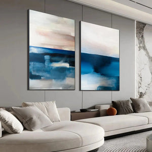 Two vertical abstract seascape paintings in blues, pinks, and beige by Willow Davies, displayed in a modern living room.