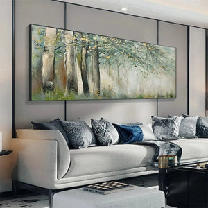 Liam O'Connell's "Whispering Woods" painting: misty forest with gold leaf accents, displayed above a gray sofa.