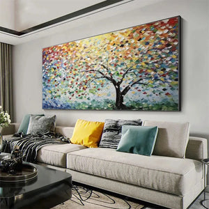 Horizontal impasto painting of a vibrant rainbow tree with textured leaves above a grey sofa in a room setting.