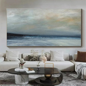 Liam O'Connell's Twilight Coast panoramic painting: muted blues and grays over dark sea, displayed above a sofa.