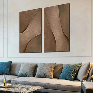 Set of 2 brown textured abstract paintings by Javier Ramirez, showcased above a sofa in a living room.