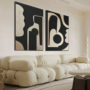 INK BLOT DUO: Set of 2 textured black and beige abstract paintings above cream sofa in living room.