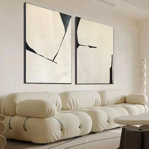 Minimalist abstract diptych, vertical wall art with black lines on beige background, displayed above cream sofa.