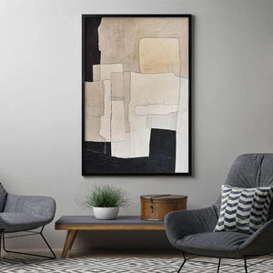 Framed beige and black abstract painting by Javier Ramirez in a modern living room with grey chairs.
