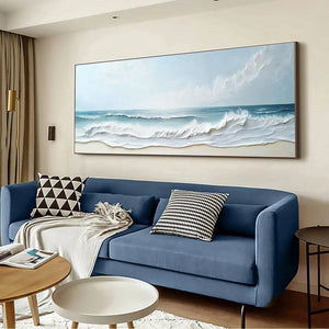 Liam O'Connell "Ocean Waves Panoramic" painting displayed above a blue sofa in a living room setting.