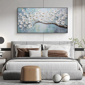 White Blossoms textured floral oil painting with gold centers above grey upholstered bed in modern bedroom.