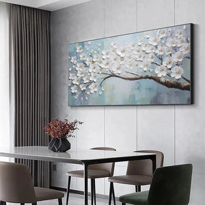 Horizontal textured white blossoms floral painting in blue, enhancing a modern dining room above a dark table.