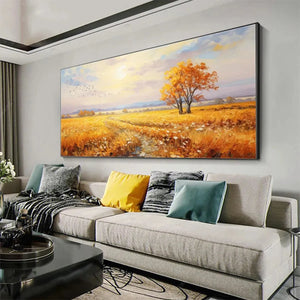 Golden Harvest original landscape painting showing golden field with autumn trees at sunset, displayed above modern grey sofa.