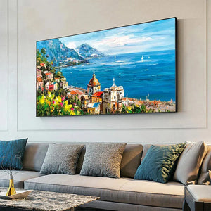 Impasto oil painting of a Mediterranean town, blue sea, and mountains, displayed in a lifestyle setting. Panoramic wall art.
