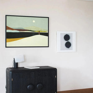 Isabella Rossi 'Solitary Figure' horizontal wall art, framed, soft colors, minimalist landscape above black cabinet.