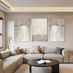 Abstract waterfall triptych: 3 minimalist paintings with beige, grey, white tones and gold frames.