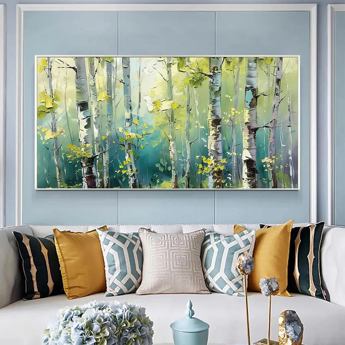 Panoramic impasto painting of a white birch forest with yellow-green leaves, displayed above a sofa in a lifestyle setting.