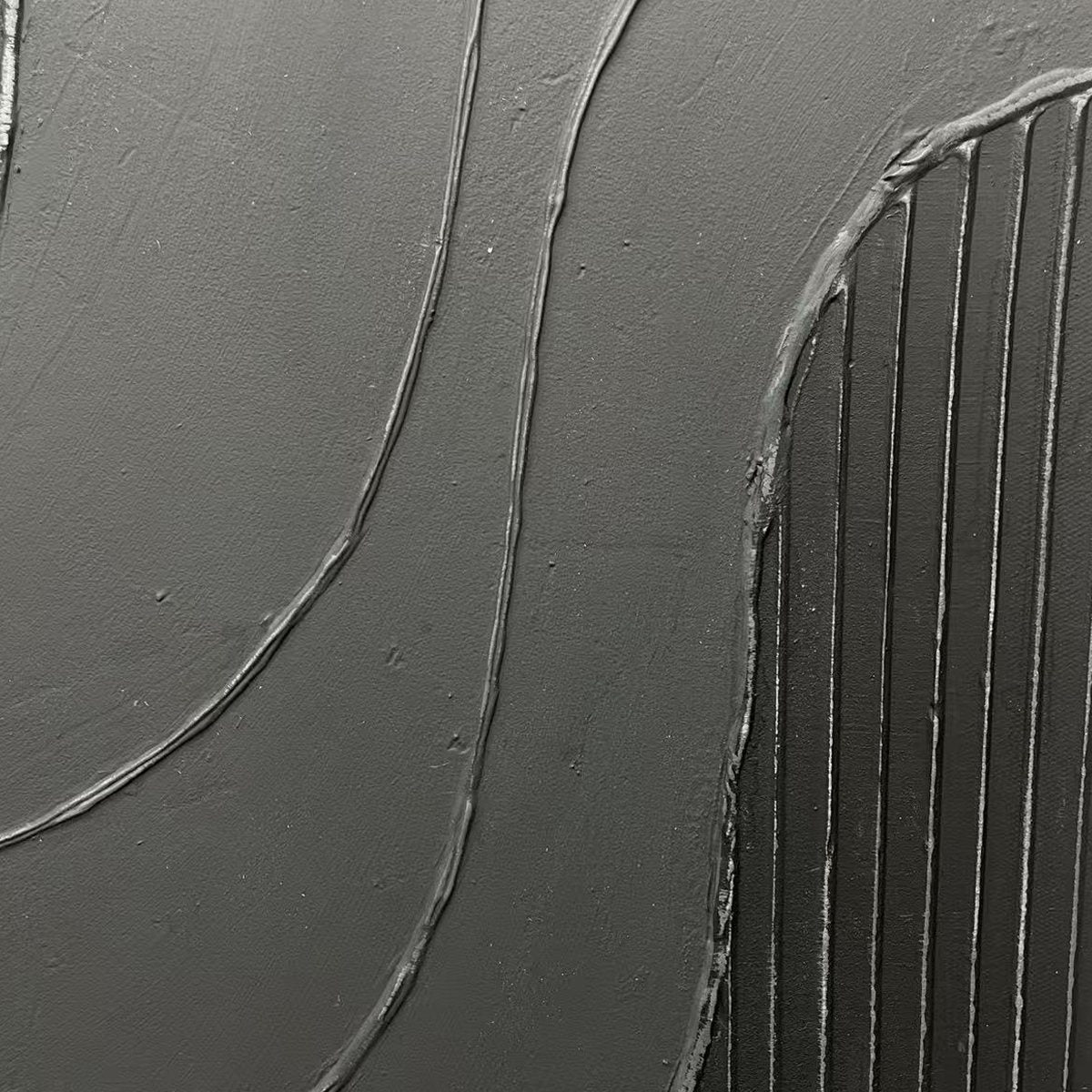 Close-up of black textured diptych with raised wavy lines and vertical ridges, showcasing tactile depth.