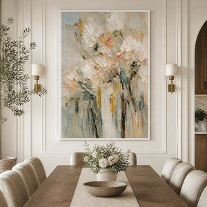 Pastel floral bouquet painting with textured petals in a white frame displayed in a refined dining room.