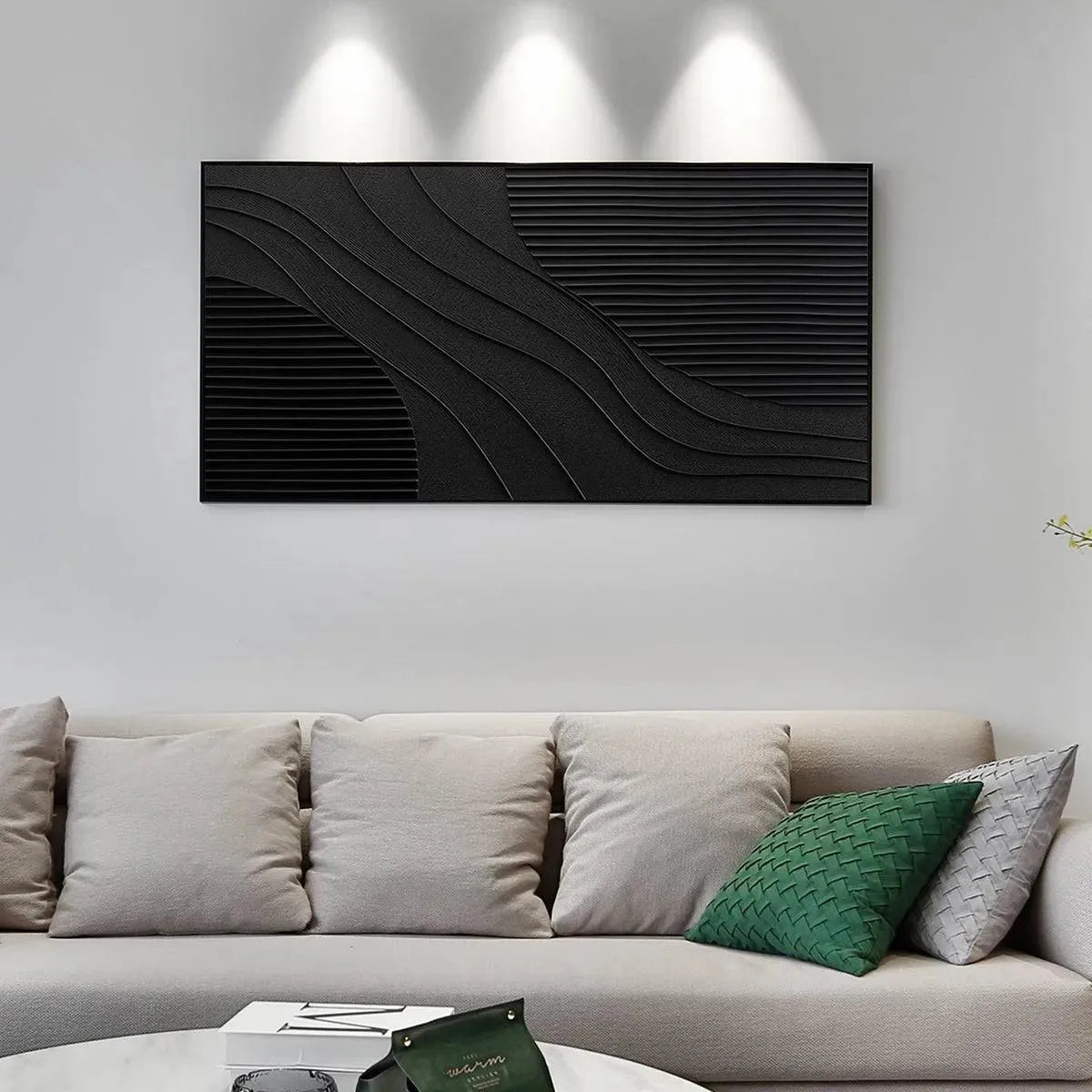 Horizontal black textured painting with abstract wave ridges and linear patterns displayed above a sofa.