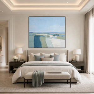 Abstract coastal landscape painting in blue, green, and white above a modern bedroom bed