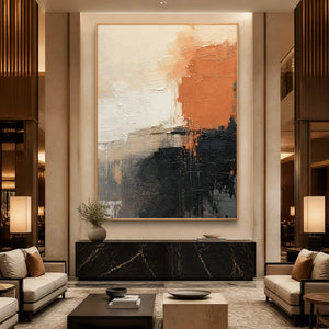 Modern vertical abstract wall art with coral, black and neutral textured tones in a wood frame displayed in a luxury hotel lobby.