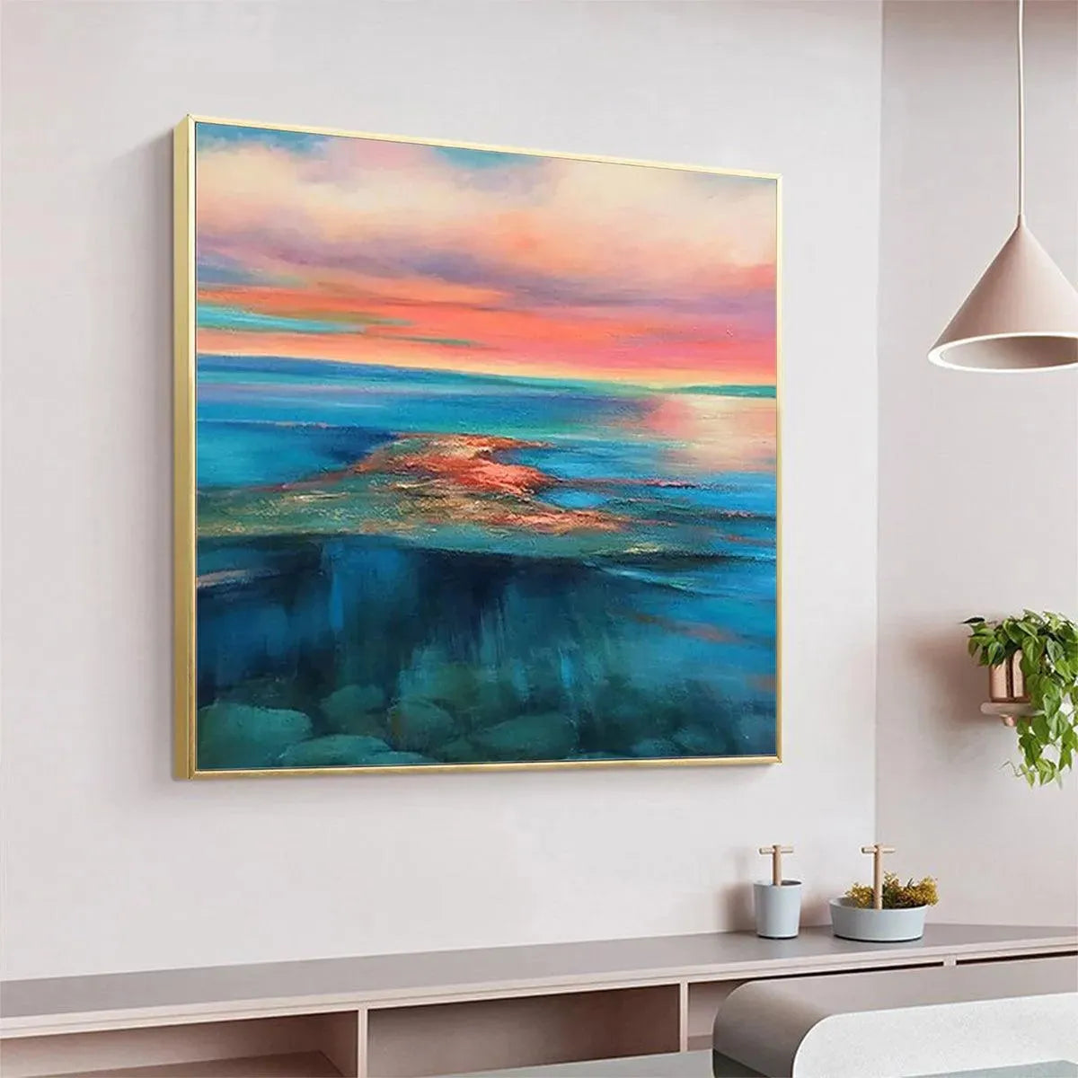 Liam O'Connell's Coral Reef Sunset painting, vibrant pink and orange sky over blue ocean water, gold frame. Room decor.