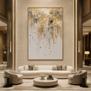 Gold leaf drip abstract painting with textured white and beige layers displayed in a luxury hotel lobby.