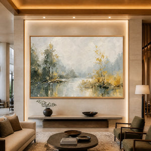 Large textured landscape artwork of a misty lake, framed in natural wood, hanging above a contemporary minimalist console table in a warm-toned living room.