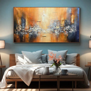 GOLDEN CITY painting by Isabella Rossi, framed abstract cityscape in orange and blue. Textured artwork above a bed.