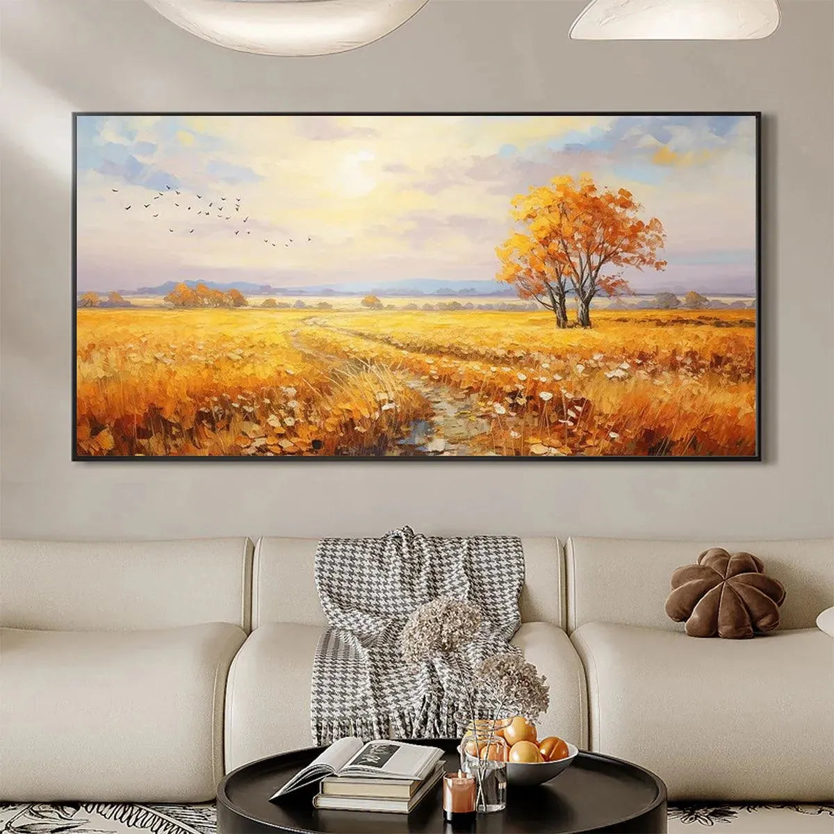 Golden Harvest landscape painting of a golden field with autumn tree and birds at sunset, over modern living room sofa.