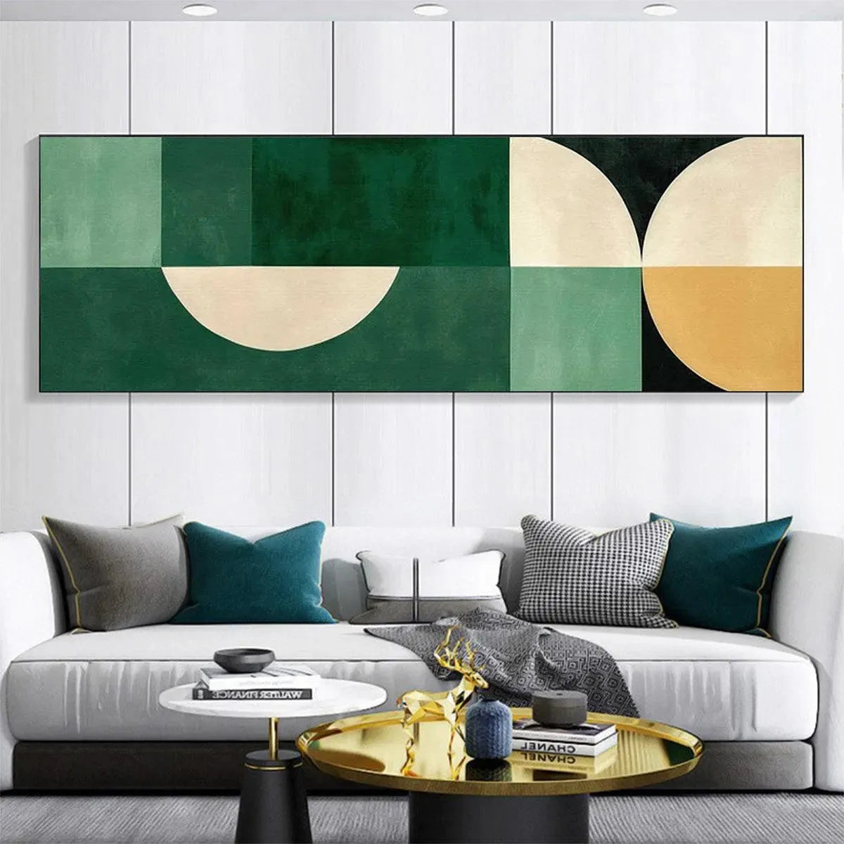 Green geometric panoramic abstract painting with cream and mustard accents above white sofa in minimalist living room.