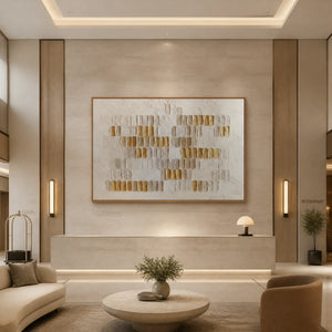 White and gold relief abstract wall art with sculpted texture in a wood frame displayed in a luxury hotel lobby.