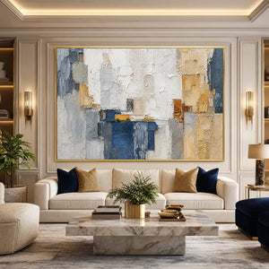 Textured abstract cityscape painting in blue, white, and gold above a modern sofa