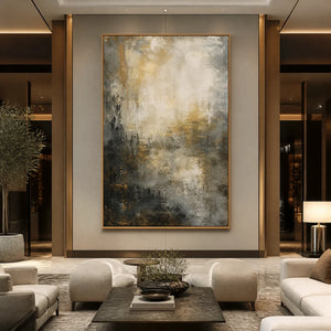 Large vertical abstract wall art in black, gray and gold in a wood frame displayed in a luxury hotel lobby.