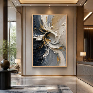 Abstract spiral wall art with white, navy and gold textured palette knife strokes in a wood frame displayed in a luxury hotel lobby.