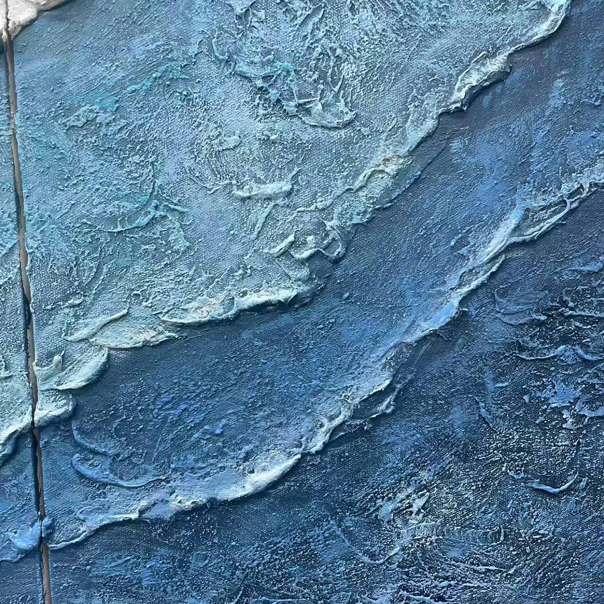 Close-up textured abstract painting with impasto strokes in blues and white, showcasing ocean wave detail.