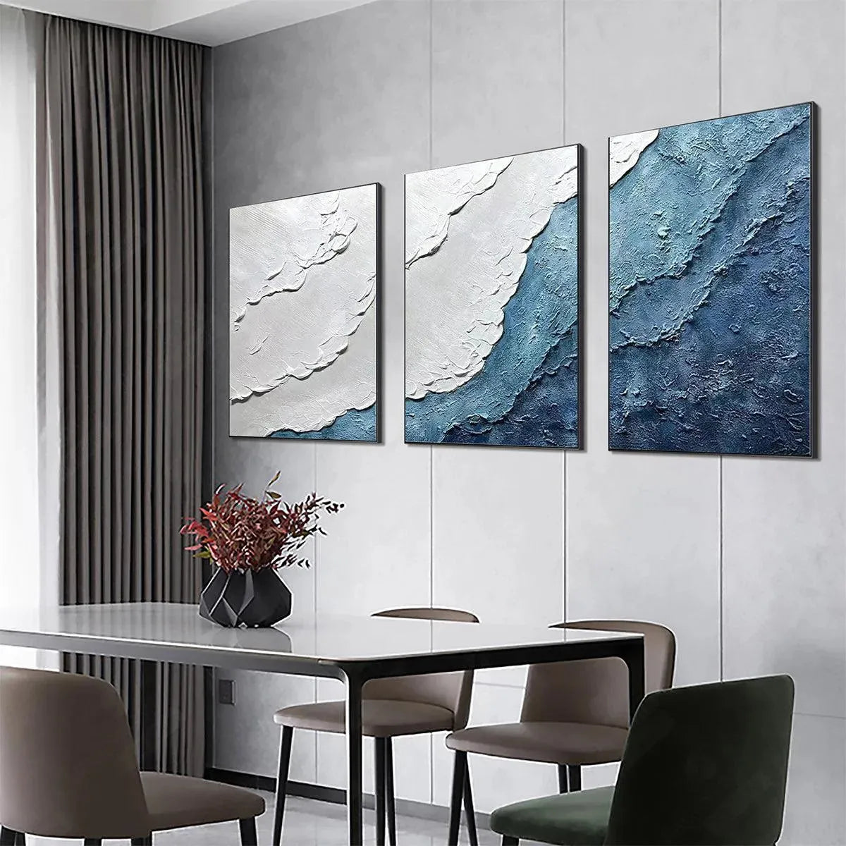 Textured triptych abstract painting set in blues and white, resembling ocean waves, shown in a dining room setting.